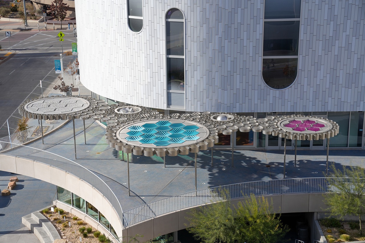 Weatherscape 坐落於 El Paso 兒童博物館二樓露台，以大尺度天篷介入戶外活動空間。天篷由蜂巢狀模組構成，透過參數化設計生成複雜曲面。